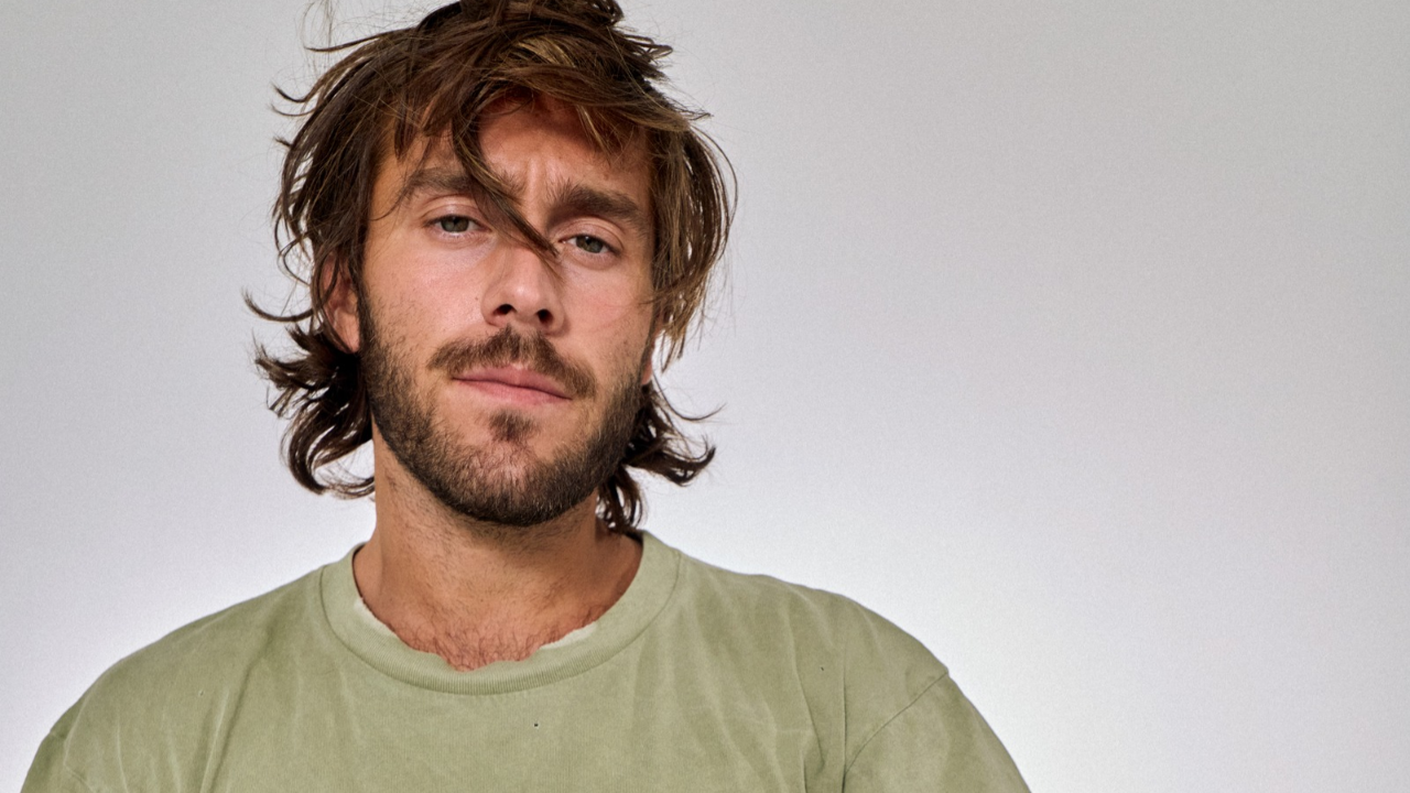 Benjamin Ingrosso in a khaki tshirt with his hair slightly over his face