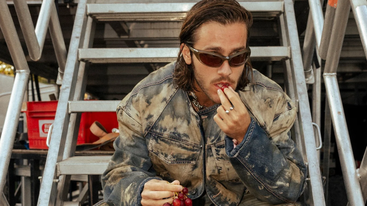 Benjamin Ingrosso in a faded denim jacket eating grapes